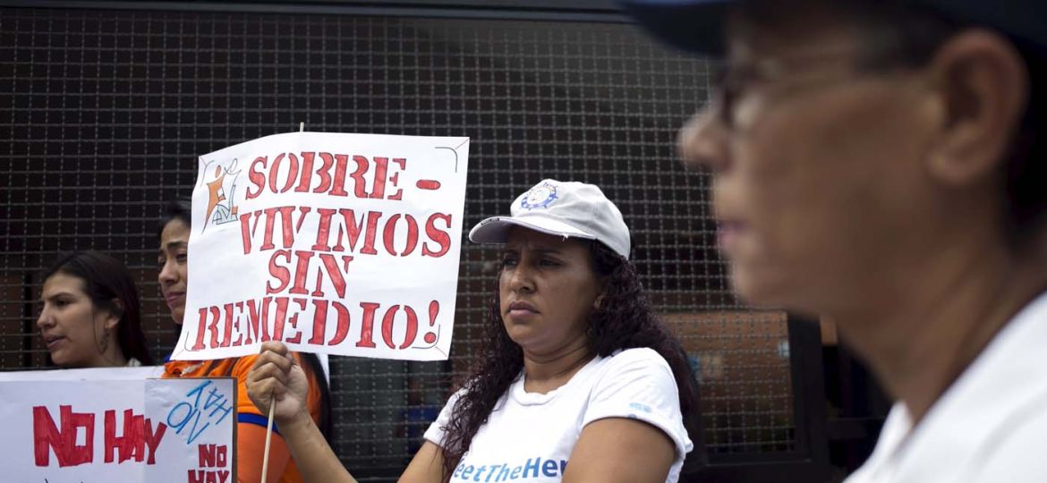 A protester holds a placard which reads "Surviving without remedy" during a gathering in demand for medicines in Caracas