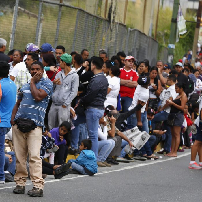 People line up outside a state-run Bicentenario supermarket in Caracas