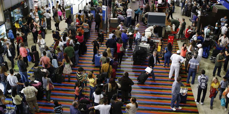 Passengers line up for the security checkpoint at Simon Bolivar airport in La Guaira