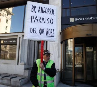 A-man-protests-while-holding-a-banner-in-Madrid