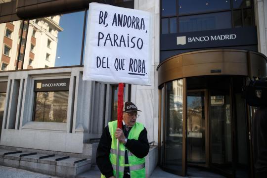 A-man-protests-while-holding-a-banner-in-Madrid