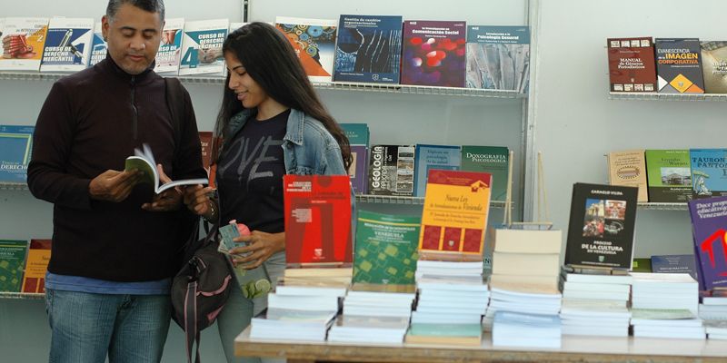 Stand feria del libro con gente-bres