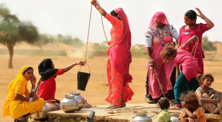 Unidentified women draw water form the well and take it to their home.