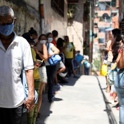 Personas forman una fila para recibir alimentos de una organización benéfica, en Carapita, un barrio pobre de la capital, durante la cuarentena debido al brote de la enfermedad por coronavirus (COVID-19), en Caracas