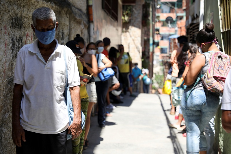 Personas forman una fila para recibir alimentos de una organización benéfica, en Carapita, un barrio pobre de la capital, durante la cuarentena debido al brote de la enfermedad por coronavirus (COVID-19), en Caracas