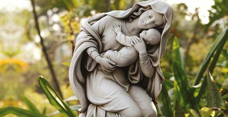 virgen-maria-estatua-abrazando-al-nino-jesus-fondo-verde-arboles