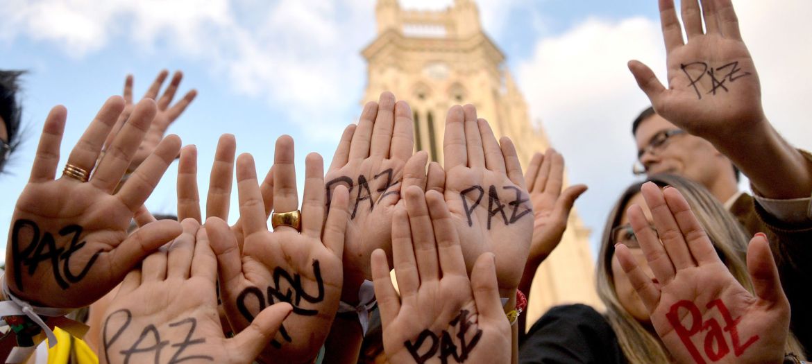 zzzzinte1Supporters of Colombian president and presidential candidate Juan Manuel Santos raise their hands with the word "Peace" written on them during a peace event in Bogota, on June 11, 2014. Colombia's government and the country's second largest guerrilla group, the National Liberation Army (ELN), announced on the eve they have opened peace talks, which adds to those taking place with the FARC, with a tense runoff presidential election just days away. AFP PHOTO/Diana Sanchez
zzzz